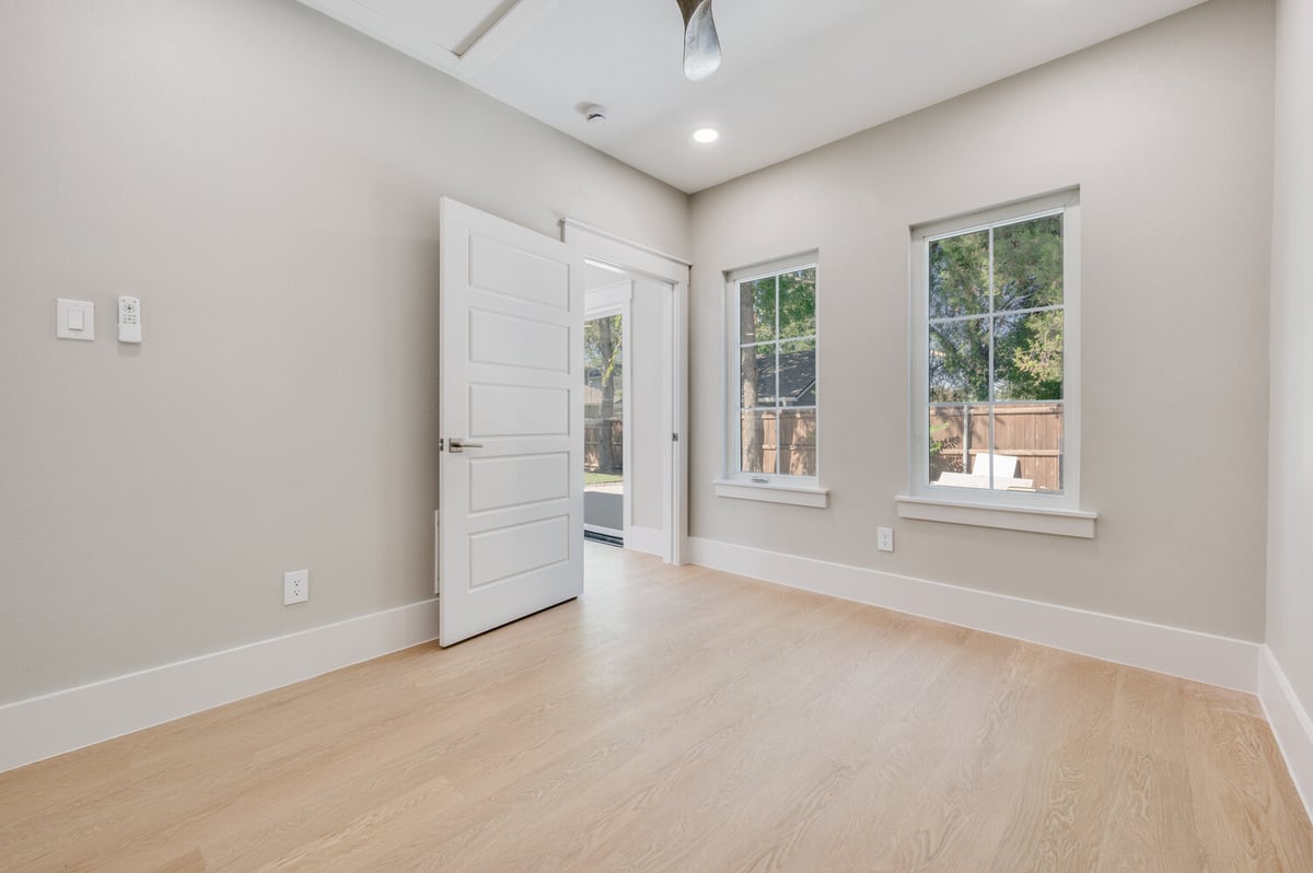 ADU bedroom in Dallas, TX by Estate ADU with light walls, two windows, and white interior door.