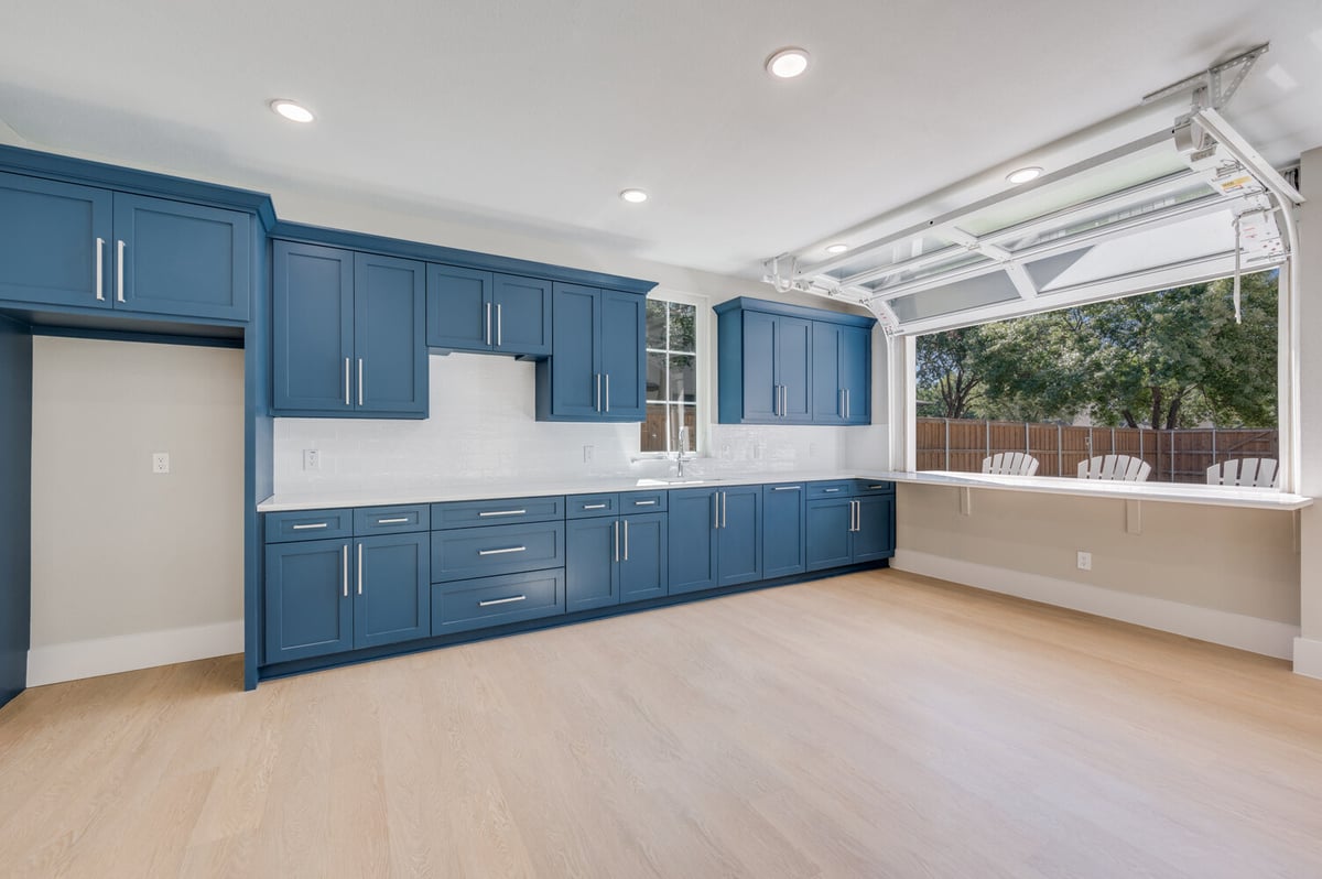 Bright and open kitchen in Dallas ADU by Estate ADU with pass-through window and blue cabinetry.