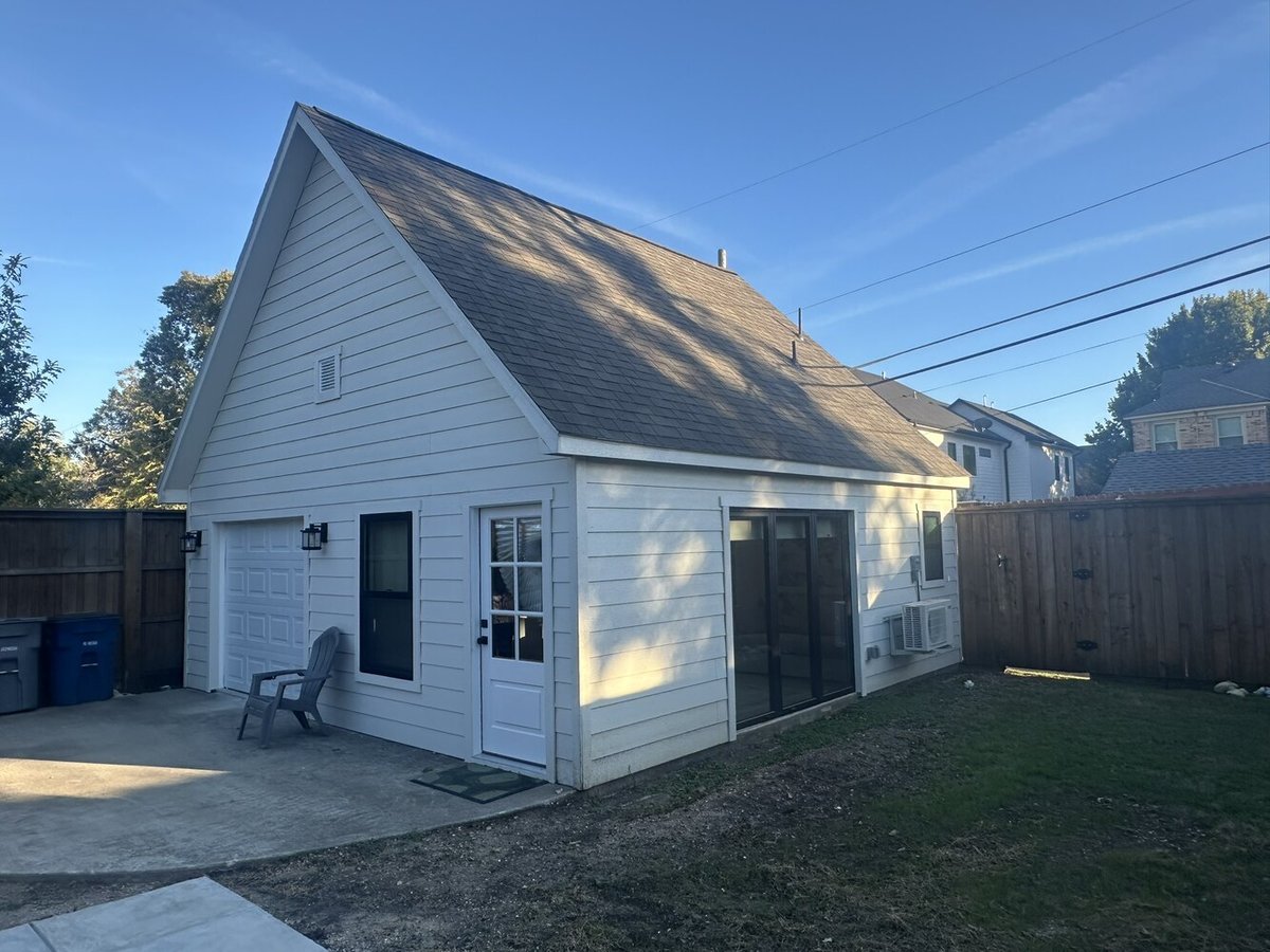 Angled view of detached ADU in Dallas, TX by Estate ADU showcasing sliding glass doors and compact lawn space.