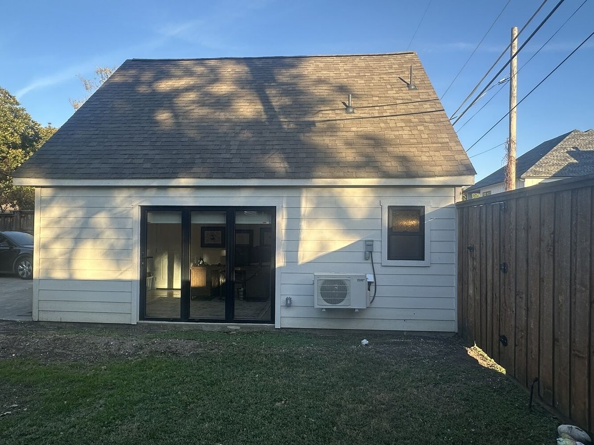 Rear exterior of custom ADU unit in Dallas, TX by Estate ADU with black-framed glass doors.