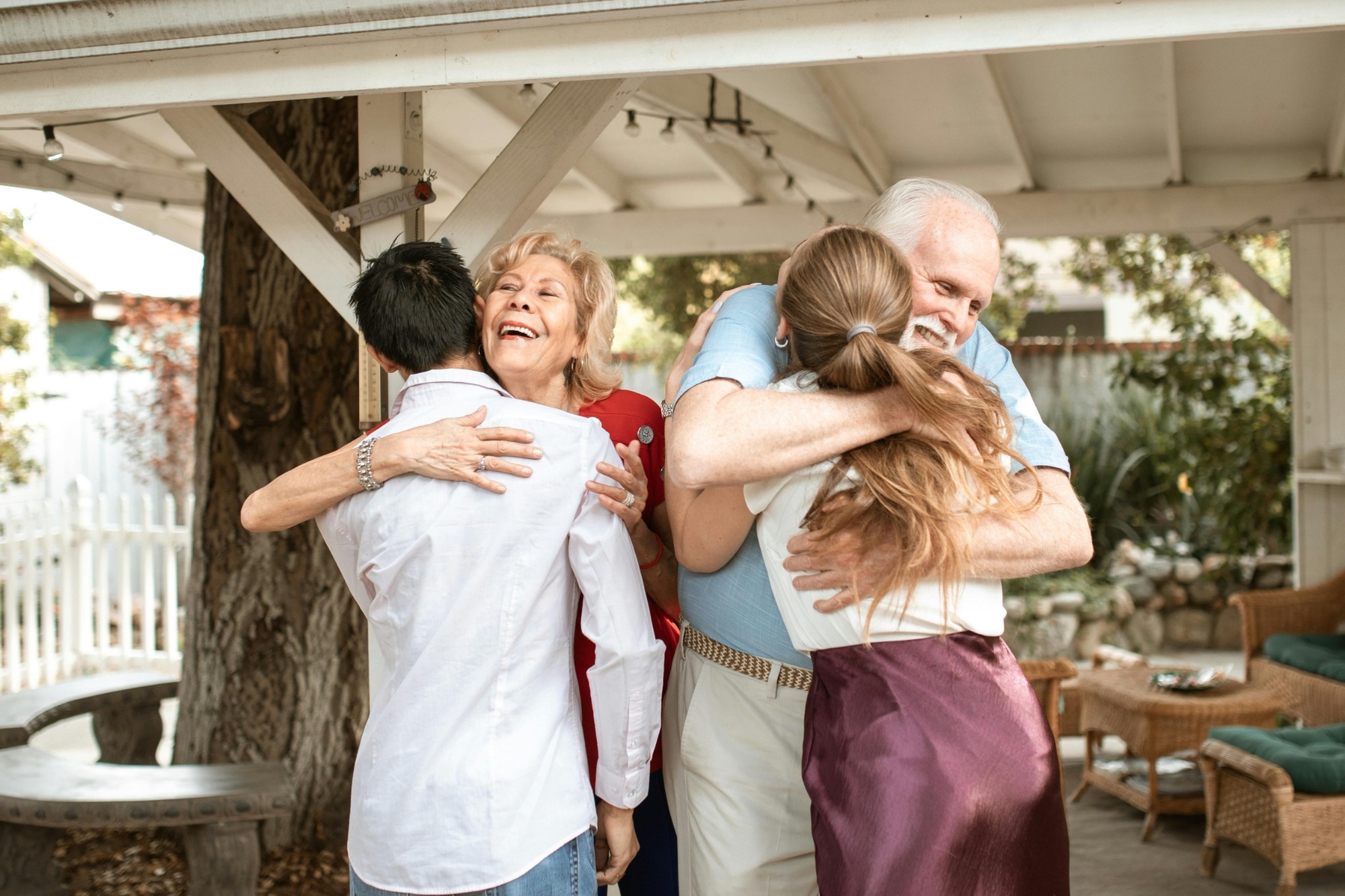 Stock image of grandparents hugging children in an outdoor patio setting