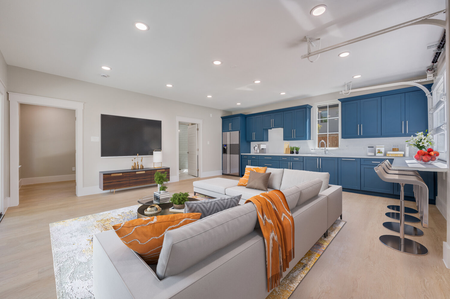 Fully furnished ADU kitchen and living space by Estate ADU in Dallas, TX with navy cabinetry and sectional sofa.