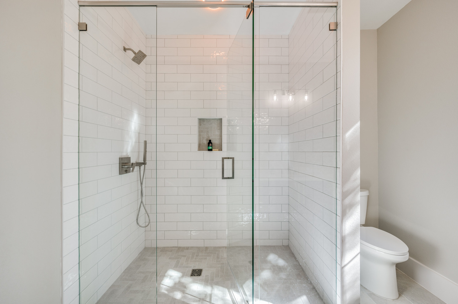 Modern walk-in shower with subway tile and glass enclosure in Dallas ADU bathroom by Estate ADU.